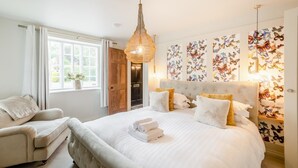 A bedroom with a large bed, a sitting area, and butterfly wall art. - 4 Bed in Helmsley (oc-l29736) (Helmsley)
