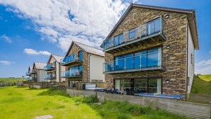 Een rij moderne, meerlaags gebouwen met gevels van natuursteen en grote glasramen.