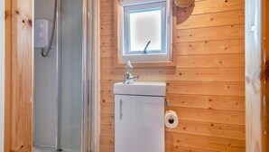 A wooden-paneled bathroom with a window, a sink, and a toilet. - 1 Bed in Cross (oc-b29655) (Cross)