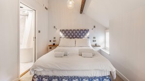 A bedroom with a bed, a bedside table, a nightstand, a hanging light fixture, and a window with blinds. - 1 Bed in Whitby (oc-e29968) (Egton Bridge)
