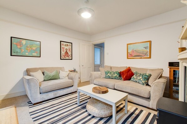 A living room with two sofas, a coffee table, and a rug. There are framed pictures on the walls. - 2 Bed in Cromer (oc-t29986) (Cromer)