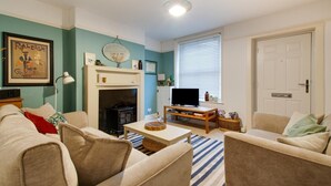 Una sala de estar acogedora con chimenea, televisor y asientos cómodos.
