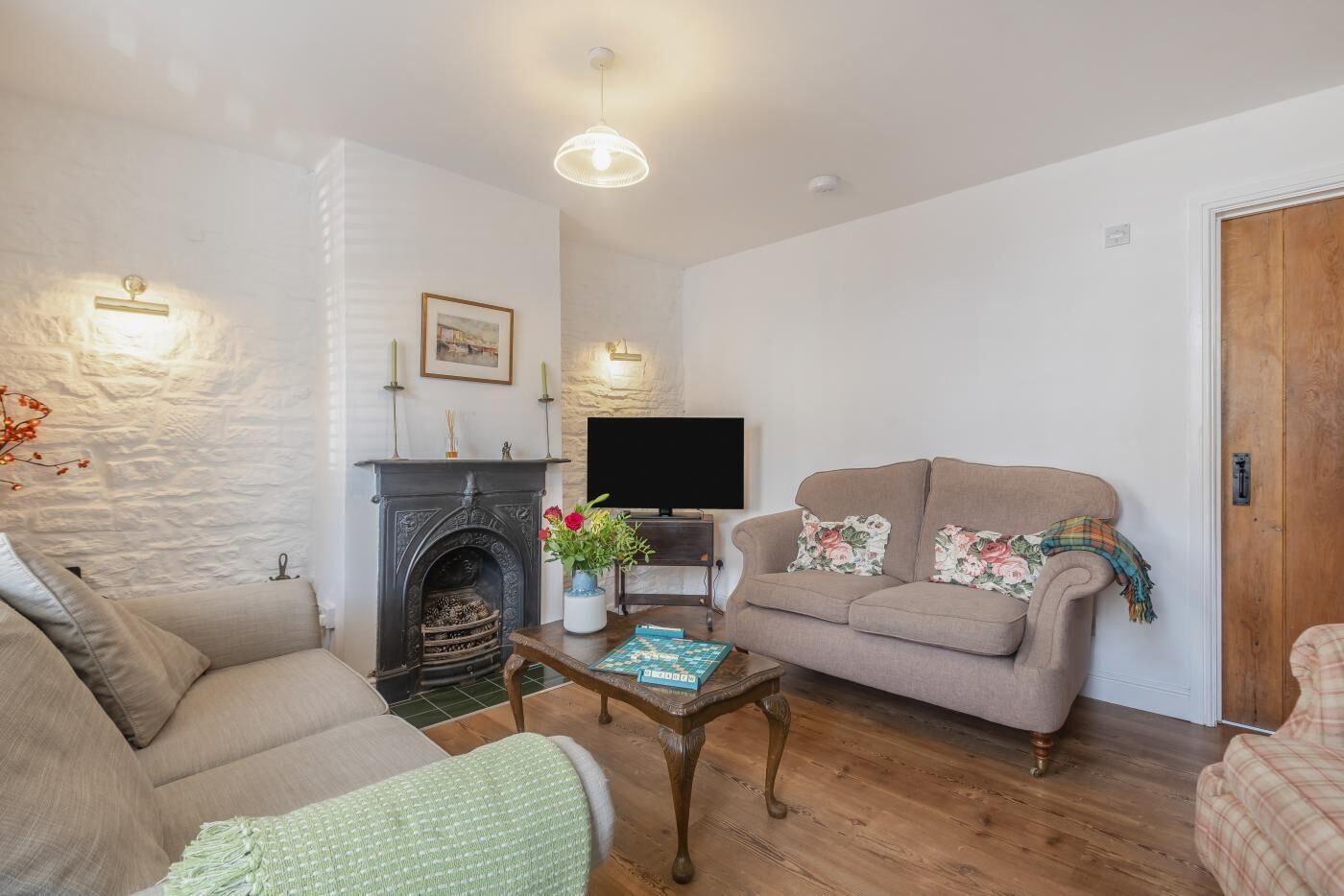 A living room with a fireplace, a sofa, a coffee table, and a television.