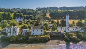 A coastal village with a prominent white lighthouse, several white houses, and lush greenery. - 2 Bed in Tayport (oc-w30005) (Dundee)