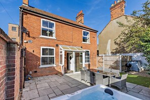 A brick house with a patio, a hot tub, and a barbecue area. - 3 Bed in Cromer (oc-r30071) (Cromer)