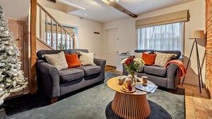 A modern living room with two grey sofas, a wooden coffee table, and a Christmas tree. - 2 Bed in Lavenham (oc-t30056) (Lavenham)