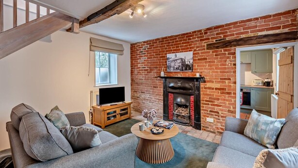 Una sala de estar acogedora con chimenea, televisor y sofá.