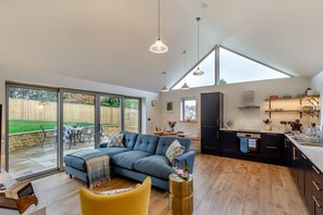 A spacious living area with a sofa, a dining table, and a kitchen with modern appliances. - 2 Bed in Melplash (oc-r30043) (Melplash)