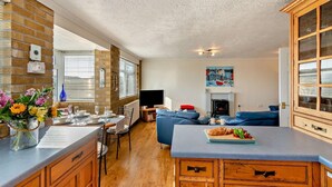 Una cocina moderna con comedor, chimenea y sala de estar con sofá.