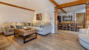 A spacious living area with a large sofa, a coffee table, and a dining table with chairs. - 3 Bed in Hartington (oc-h30059) (Hartington Nether Quarter)