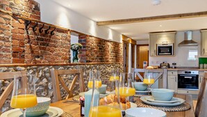 A breakfast setup with orange juice, croissants, and a rustic brick wall. - 3 Bed in Hartington (oc-h30059) (Hartington Nether Quarter)