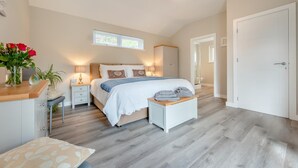 Ein Schlafzimmer mit Bett, Nachttischen, einem Schrank und einem Fenster.