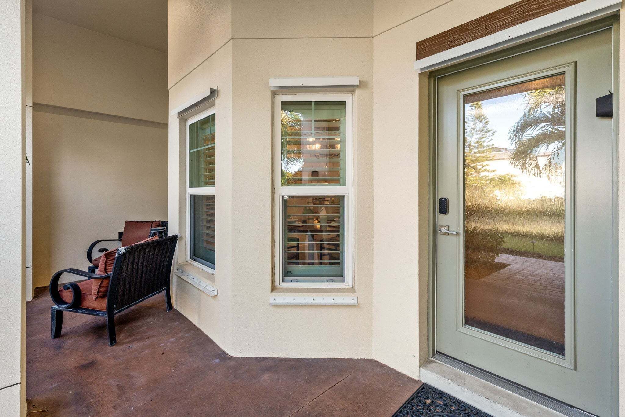 A building entrance with a bench, two windows, and a door.