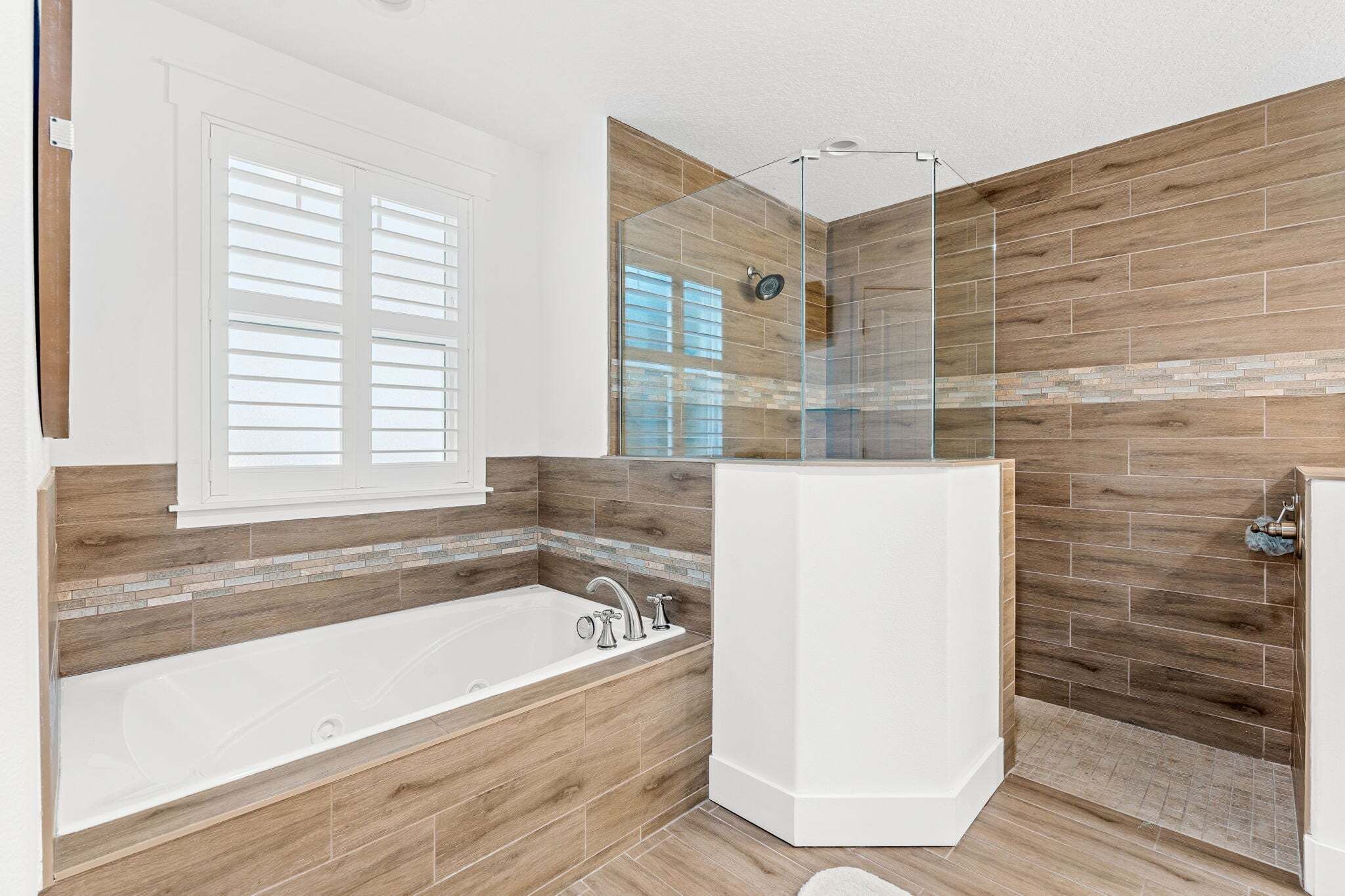 A bathroom with a bathtub, shower, and a glass-enclosed shower area.