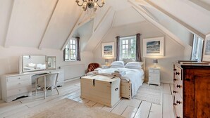 A bedroom with a large bed, a desk, a chair, a dresser, and a chest of drawers. - 5 Bed in Sedlescombe (oc-c30096) (Sedlescombe)