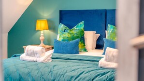 Une chambre d’hôtel avec un lit, des oreillers, une lampe et une table de chevet.