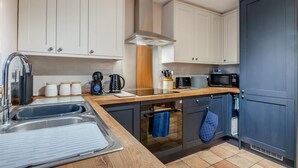 Eine moderne Küche mit Spüle, Herd, Mikrowelle und Schränken.