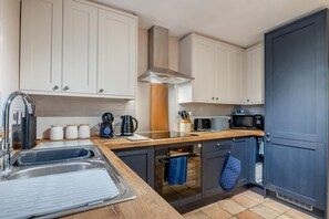 Eine moderne Küche mit Spüle, Herd, Mikrowelle und Schränken.