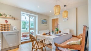 A cozy kitchen with a dining area, wooden furniture, and a large window. - 2 Bed in Aldbrough St. John (oc-l30130) (Aldbrough Saint John)