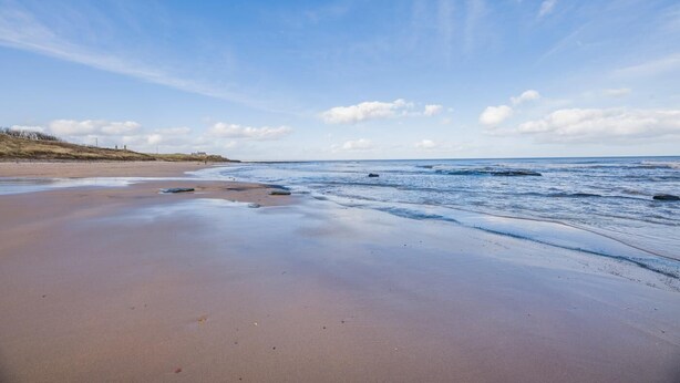 A beach with a wide sandy shore, gentle waves, and a clear sky. - 2 Bed in Cresswell (oc-c30144) (Cresswell)