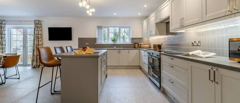 Mikrobølgeovn, ovn, oppvaskmaskin og høy barnestol