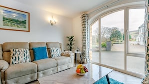A living room with a sofa, a coffee table, and a large window with curtains. - 2 Bed in Capel Bangor (oc-m30146) (Capel Bangor)