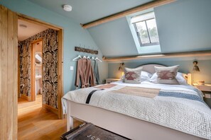 A bedroom with a sloped ceiling, a bed with a quilt, a window, and a wall-mounted light fixture. - 2 Bed in Cwmdu (oc-l30162) (Cwmdu)