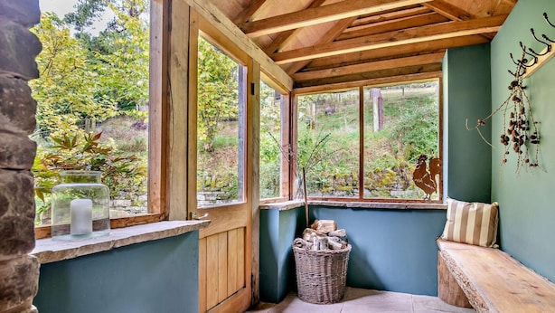 A cozy corner with a bench, a stone wall, and a window overlooking a garden. - 2 Bed in Cwmdu (oc-l30162) (Cwmdu)