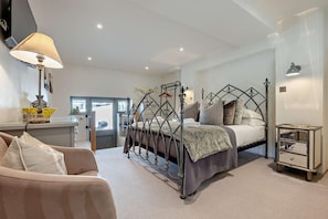 A bedroom with a metal bed frame, a bedside table, a lamp, and a chair. - 5 Bed in St. Issey (oc-r4328) (Saint Issey)