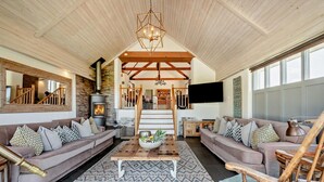 A spacious living room with a fireplace, wooden ceiling beams, a large mirror, and a television. - 5 Bed in St. Issey (oc-r4328) (Saint Issey)