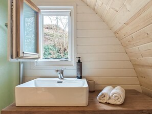A bathroom with a white sink, a window, and a towel on the counter.