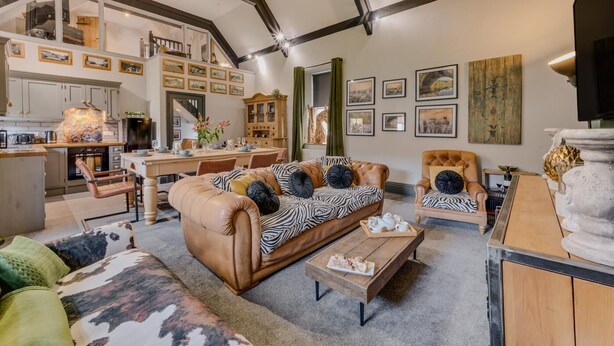 A spacious living area with a high ceiling, a dining table, and a kitchen in the background. - 3 Bed in Richmond (oc-t30197) (Richmond)