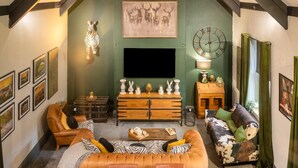 A cozy living room with a sofa, a wooden coffee table, a television, and a decorative wall clock. - 3 Bed in Richmond (oc-t30197) (Richmond)