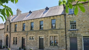 A stone building with multiple windows, a door, and a garage. - 3 Bed in Richmond (oc-t30197) (Richmond)