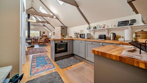 Een moderne keuken met een centraal eiland, een ingebouwde oven en een groot raam boven het fornuis.