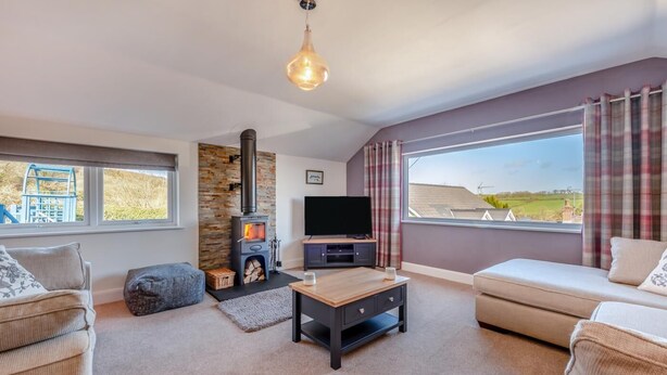 A cozy living room with a stone fireplace, a television, and comfortable seating. - 3 Bed in St. Dogmaels (oc-y30253) (Saint Dogmaels)