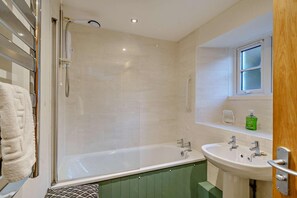 Ein Badezimmer mit Dusche, Badewanne, Waschbecken und einem Fenster.