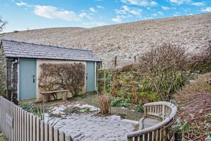 A rustic stone building with a sloped roof, a bench, and a wooden fence. - 2 Bed in Hawkshead (oc-v30277) (Claife)