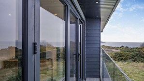 A modern building with large glass windows and a view of the sea. - 3 Bed in Totland Bay (oc-s30266) (Totland)