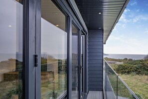 Ein modernes Gebäude mit großen Glasfenstern und Blick auf das Meer.