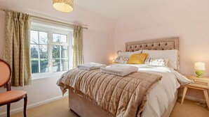A bedroom with a bed, a chair, a window, and a nightstand with a lamp. - 2 Bed in Nacton (oc-c30257) (Nacton)