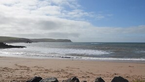 A beach with a rocky shoreline and distant hills. - 3 Bed in Thurlestone (oc-h30263) (Thurlestone Sands)