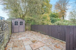 A stone wall, a wooden shed, and a wooden fence in a garden area. - 2 Bed in Oakenclough (oc-m30216) (Oakenclough)