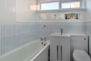 Une salle de bain avec une baignoire, un lavabo et des toilettes.