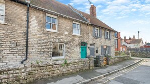 A stone-built residential street with a row of houses, each featuring a distinct entrance and a small front garden. - 3 Bed in Swanage (oc-s30316) (Swanage)