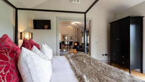Ein Schlafzimmer mit einem großen Bett, einem schwarzen Kleiderschrank und einem Fernseher an der Wand.