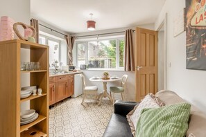 Una habitación acogedora con kitchenette, una mesa de comedor con sillas y un sofá.