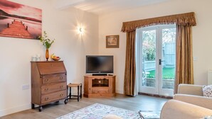 A living room with a wooden cabinet, a television, a sofa, and a patterned rug. - 1 Bed in Sutton (oc-u30398) (Sutton)