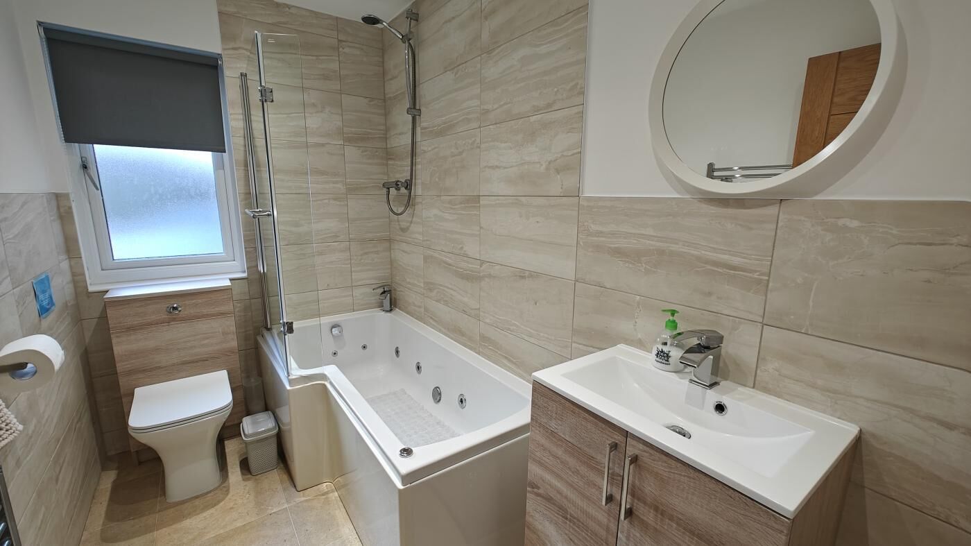 Une salle de bain moderne équipée d’une baignoire, de toilettes, d’un lavabo et d’un miroir.