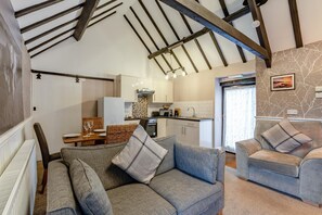 A cozy living room with a sofa and armchairs, a dining area with a table and chairs, and a kitchen with modern appliances. - 2 Bed in Hawsker (oc-c30335) (Stainsacre)